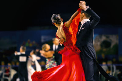 Rear view of people dancing at music concert