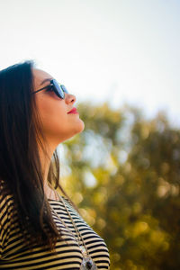 Close-up of woman in sunglasses against sky