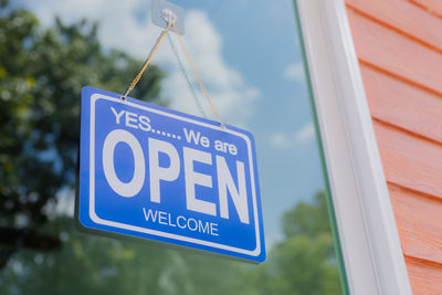 The owner of the store hangs a sign to open a business in front of the door.