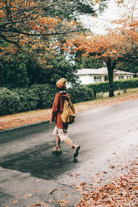 Rear view of woman walking on road