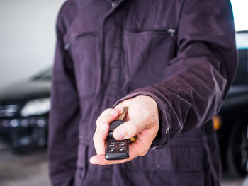 Midsection of man using mobile phone