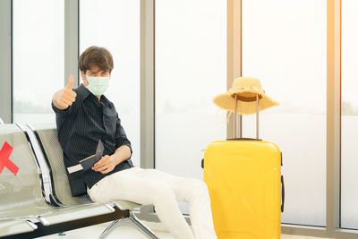 Man sitting on chair by window