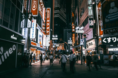 People walking on city street at night