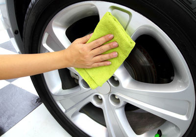 Cropped hand of man washing car