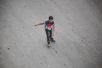 High angle view of boy standing on skateboard