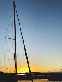 Silhouette sailboat on bridge against sky during sunset