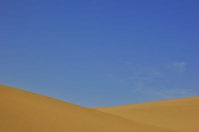 Scenic view of desert against blue sky