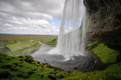 Scenic view of waterfall against sky