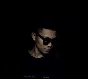 Portrait of young man wearing sunglasses against black background