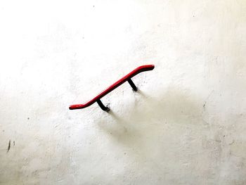 Close-up of red umbrella on white wall