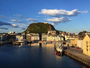 View of townscape by river against sky