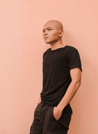 Young man looking away against white background