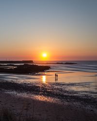 Scenic view of beach against sky during sunset