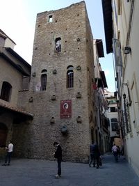 People walking on street in city against clear sky