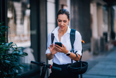 Woman using mobile phone in city