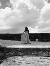 Rear view of woman with umbrella against sky