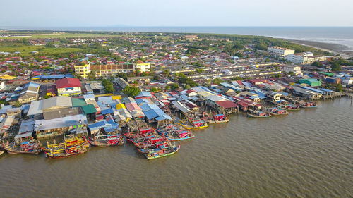 High angle view of city buildings by sea against sky