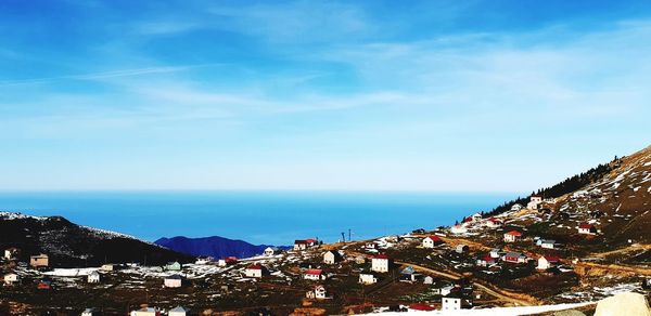 High angle view of townscape by sea against sky