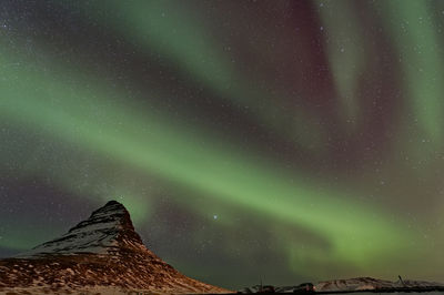 Low angle view of snowcapped mountain against sky at night