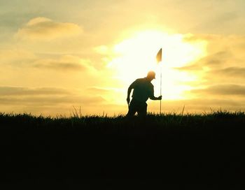 Silhouette of people on field at sunset