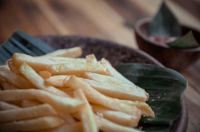 Close-up of meat and fries in plate on table