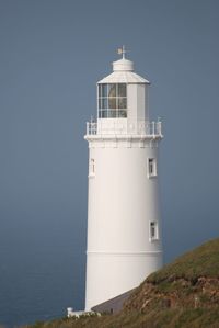 Lighthouse by sea against sky