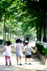 Rear view of girls walking in park