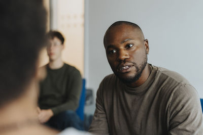 Male school counselor discussing with student at high school
