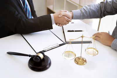 Midsection of man holding wineglass on table