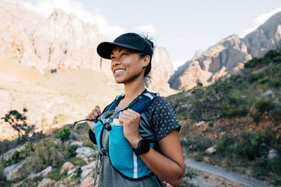 Happy woman standing against mountain