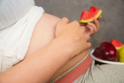 Midsection of man holding fruits