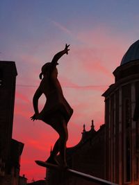 Low angle view of silhouette woman jumping against sky during sunset