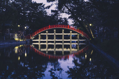 Arch bridge over lake against sky at night
