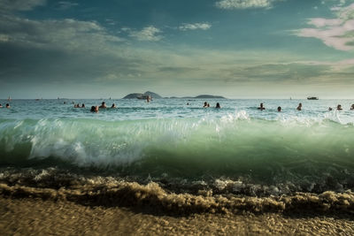 People on beach against sky