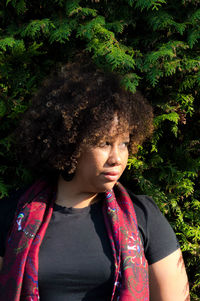 Mid adult woman looking away against tree