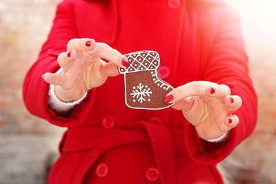 Midsection of woman holding gingerbread cookie during christmas