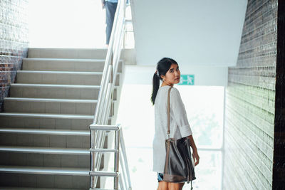 Portrait of woman standing on staircase