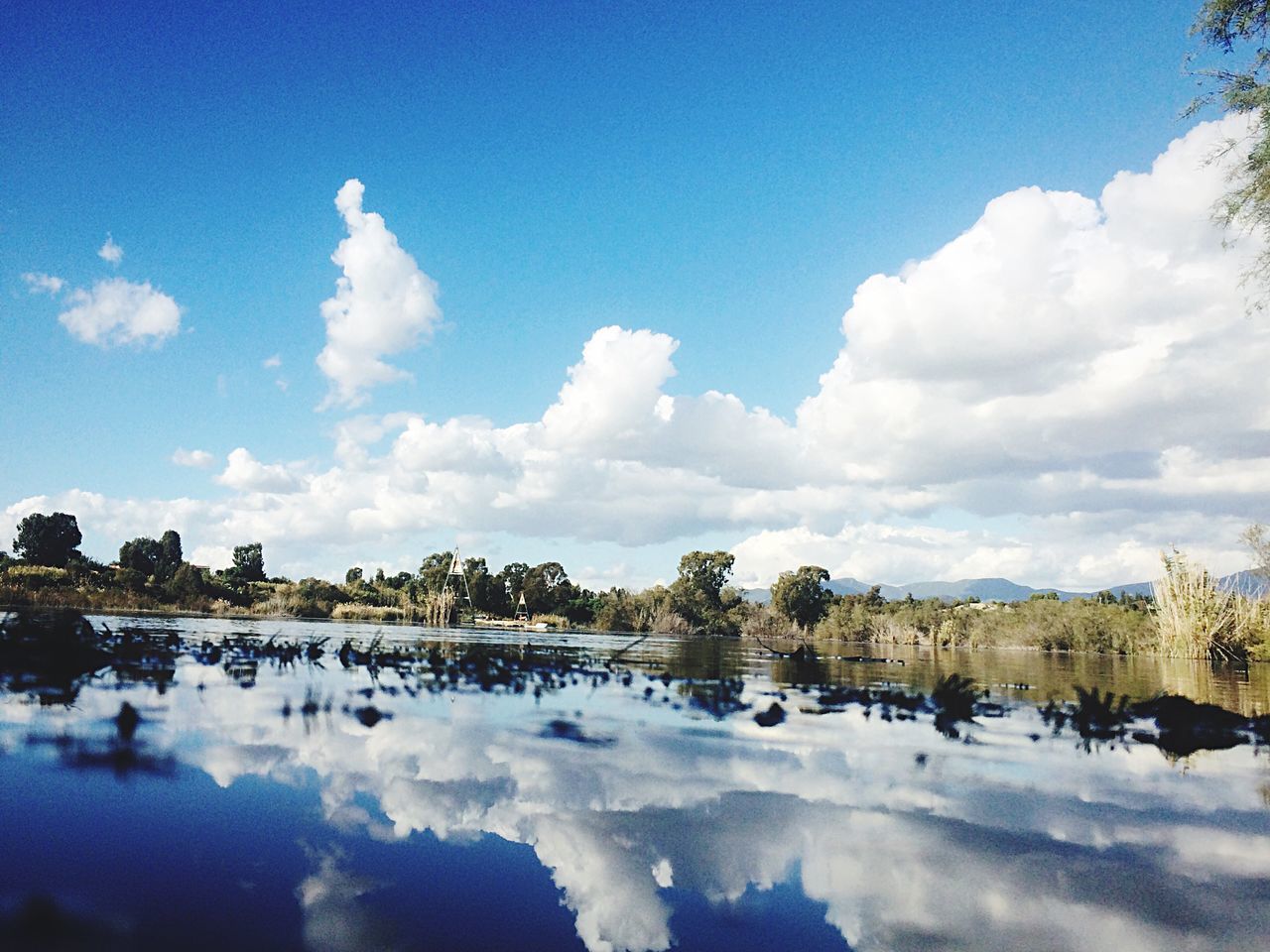 sky, blue, water, tranquil scene, scenics, tranquility, cloud - sky, beauty in nature, reflection, nature, cloud, lake, day, waterfront, idyllic, outdoors, landscape, no people, tree, non-urban scene