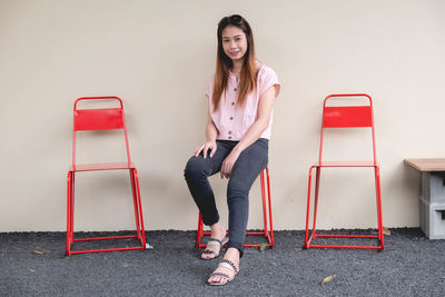 Portrait of young woman sitting on chair