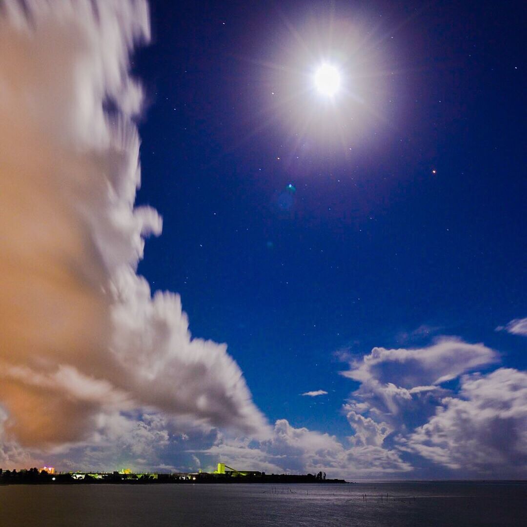 sky, water, scenics, cloud - sky, beauty in nature, tranquil scene, tranquility, waterfront, sea, nature, sun, cloudy, sunbeam, cloud, idyllic, blue, reflection, weather, outdoors, sunlight