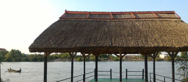 Built structure by river against sky