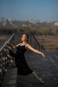 Young woman with arms outstretched standing outdoors