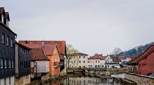 Houses and buildings in town against sky