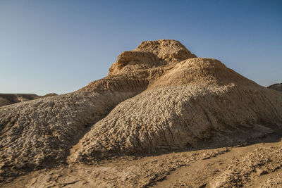 Scenic view of desert mountain forms like cake against clear blue sky