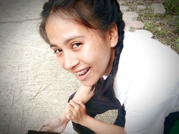 Close-up portrait young woman smiling while sitting outdoors