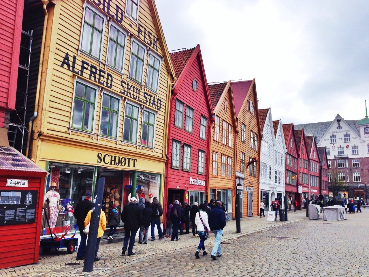 building exterior, architecture, built structure, large group of people, person, men, lifestyles, street, city, walking, sky, city life, leisure activity, mixed age range, building, outdoors, cobblestone, town square, day