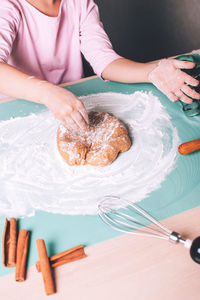 Closeup of child hands kneading fresh dough on the table for christmas gingerbread cookies