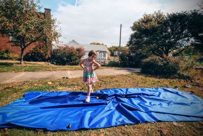 Portrait of cute girl with hand on hip standing on picnic blanket