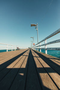 Pier in a small fishing town against clear blue sky