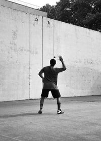 Rear view of man standing against wall